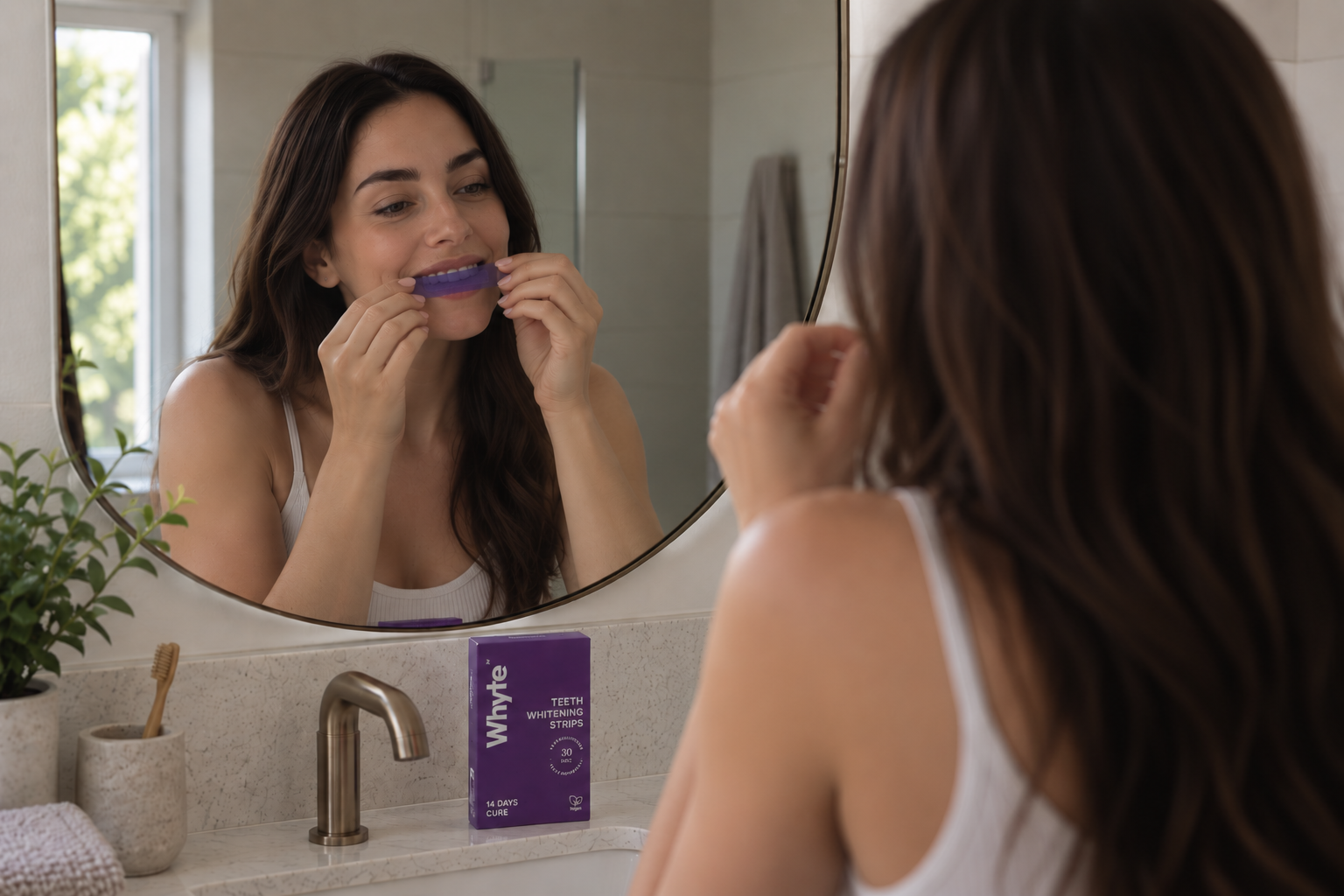 Vrouw brengt een WHYTE whitening strip aan op haar tanden